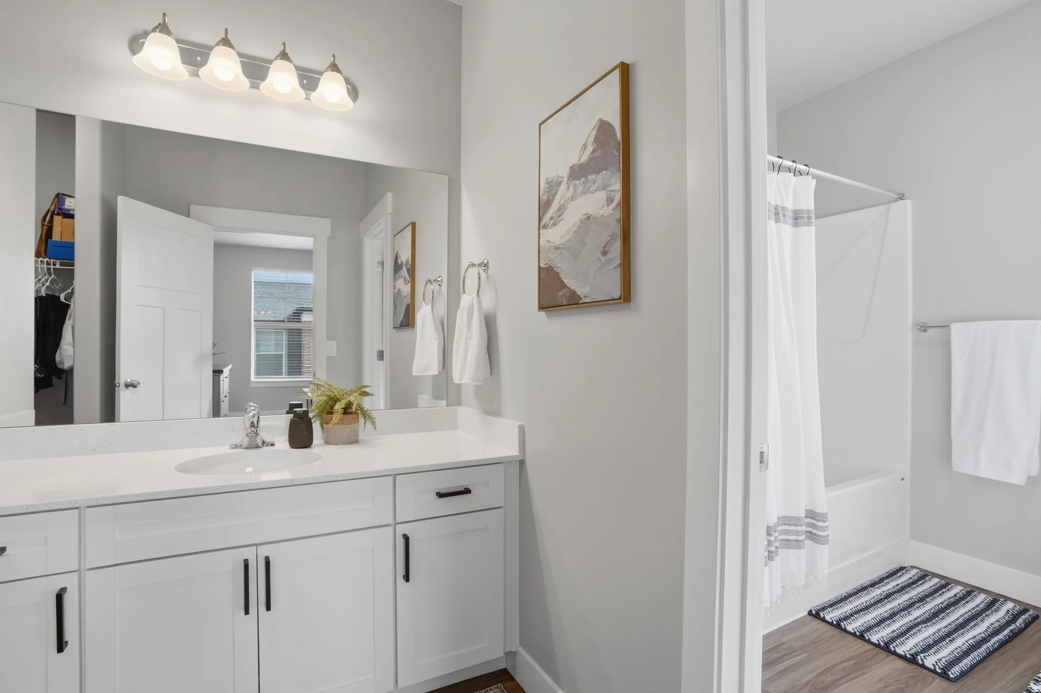 Bathroom featuring a single vanity with white cabinetry, a light-toned countertop, and an integrated sink with a chrome faucet