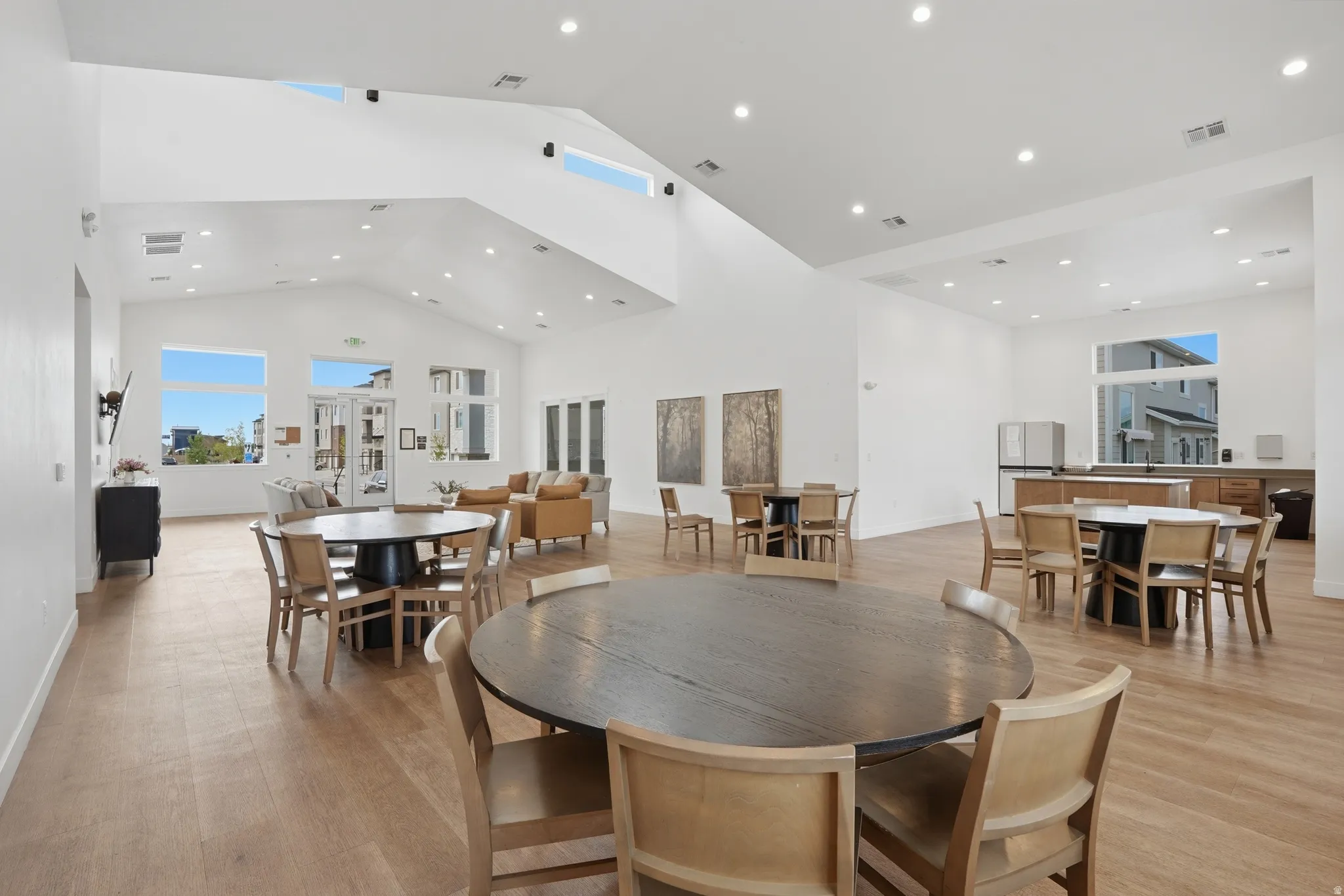 Spacious communal area featuring vaulted ceilings, light wood-finish flooring, and recessed lighting throughout