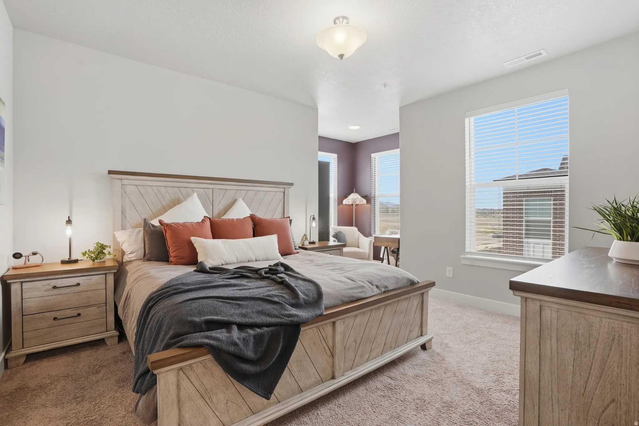 Carpeted bedroom with neutral wall paint and a flush-mount ceiling light