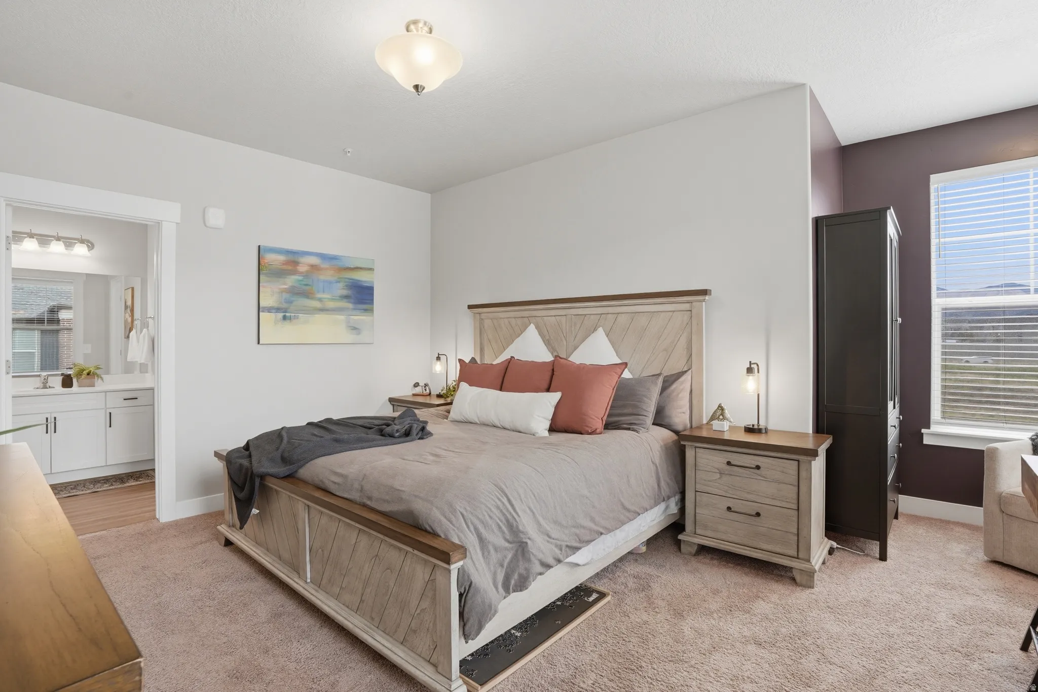Carpeted room with a ceiling-mounted light fixture and a wide window with blinds