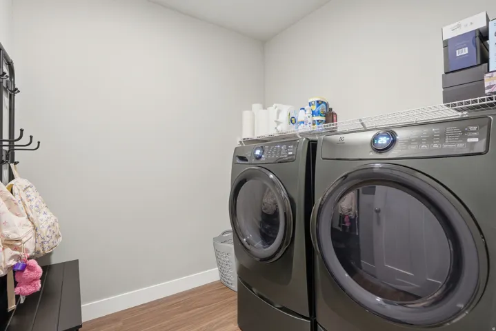 Dedicated laundry area featuring wood-finish flooring and a white wire shelf