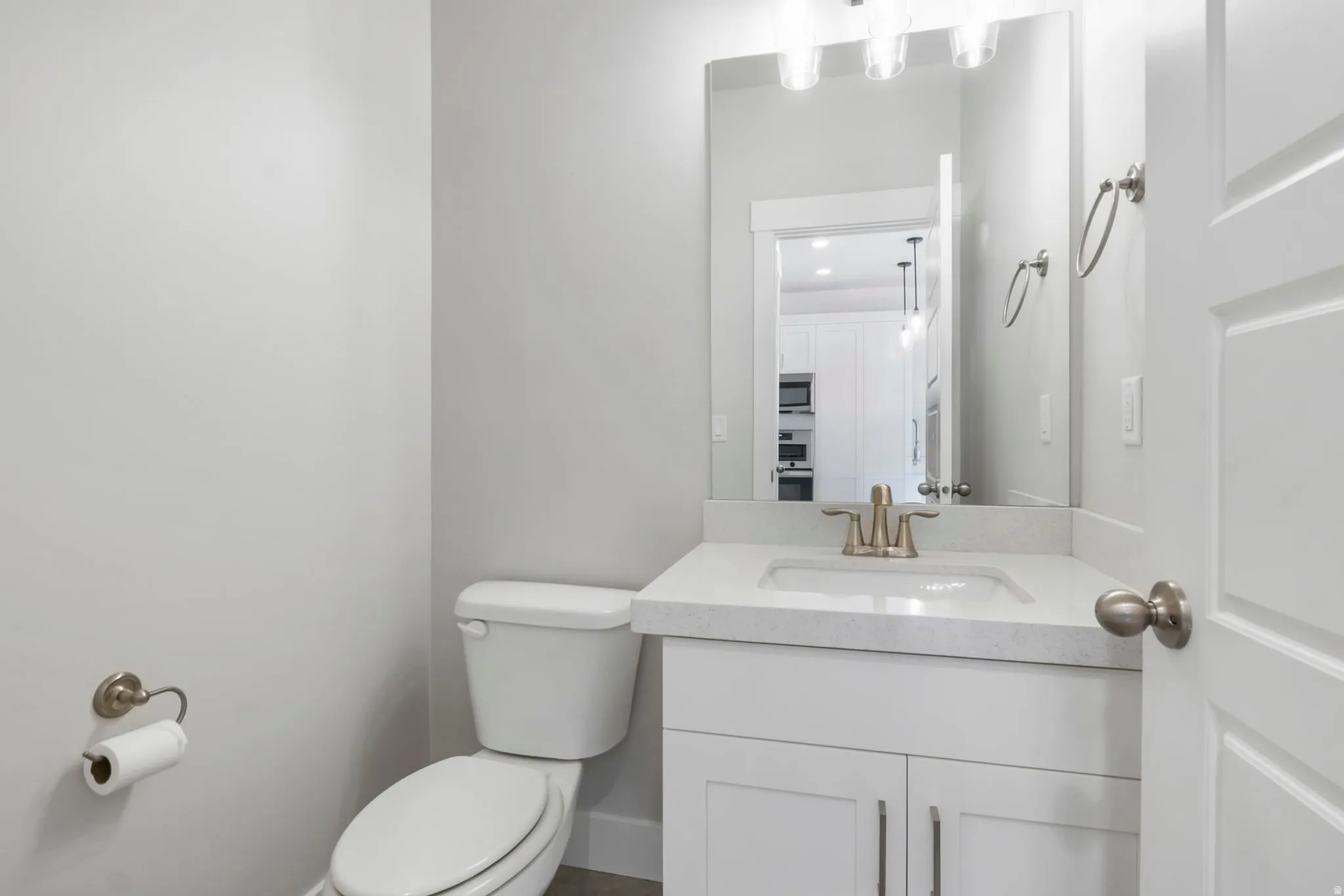 Bathroom featuring a white vanity with a light-colored countertop, integrated sink, and brushed nickel faucet