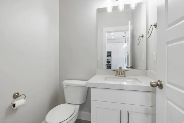 Bathroom featuring a white vanity with a light-colored countertop, integrated sink, and brushed nickel faucet