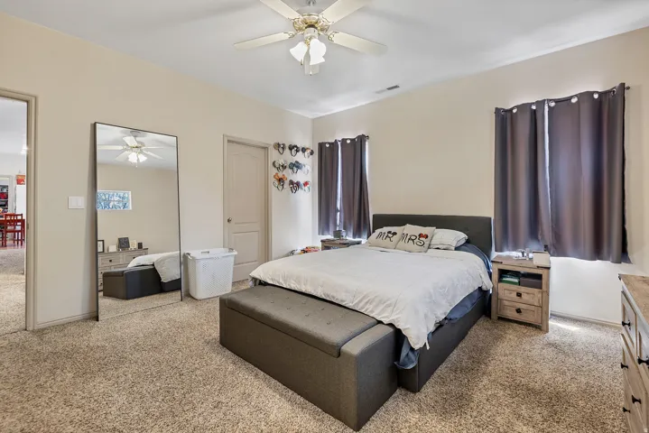 Bedroom featuring light colored carpet and ceiling fan