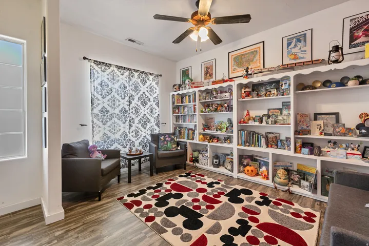 Living area with dark wood-style flooring and a ceiling fan