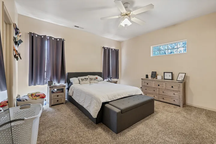 Bedroom featuring light colored carpet and a ceiling fan