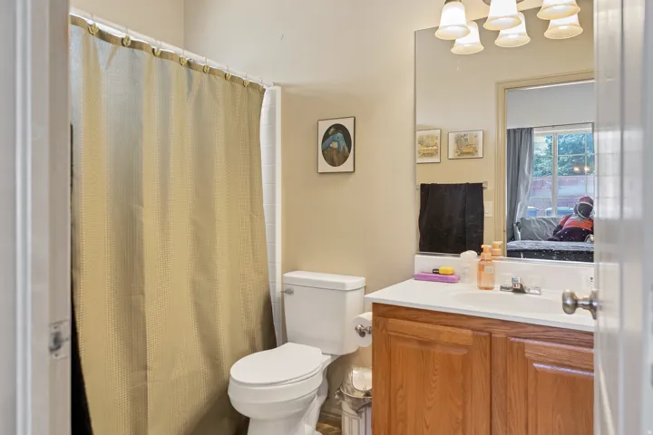 Ensuite bathroom with a shower with shower curtain and vanity