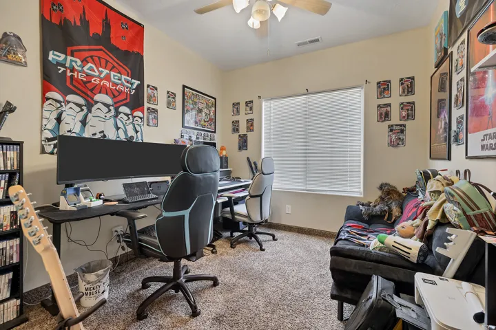 Office area featuring light colored carpet and a ceiling fan