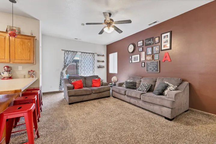 Living room featuring light carpet and ceiling fan
