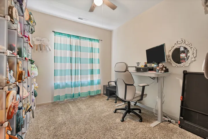 Office with light carpet and ceiling fan