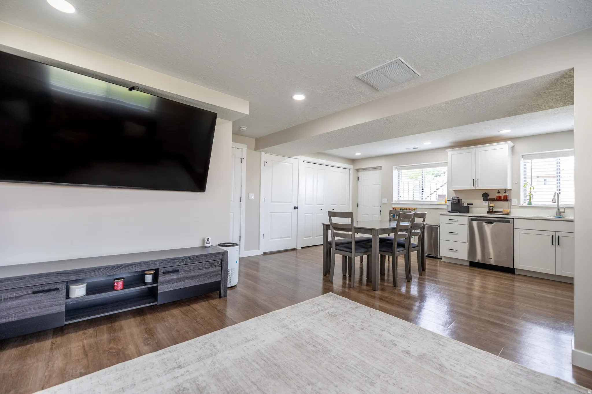 Living room featuring dark wood finished floors, a textured ceiling, and recessed lighting