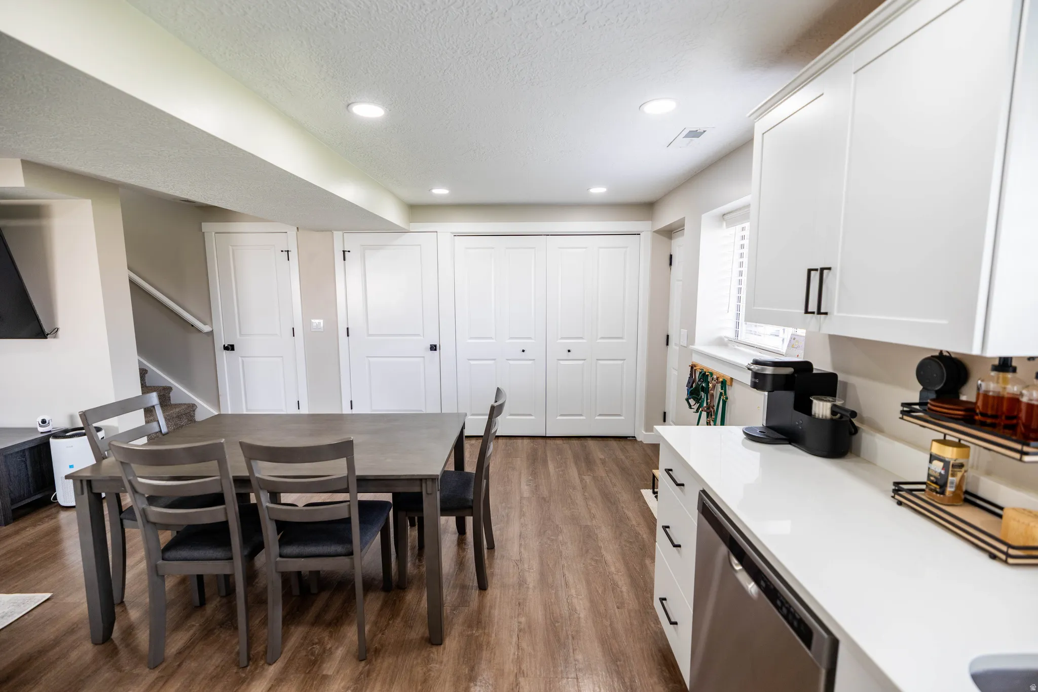 Dining area featuring dark wood-type flooring, a textured ceiling, and recessed lighting