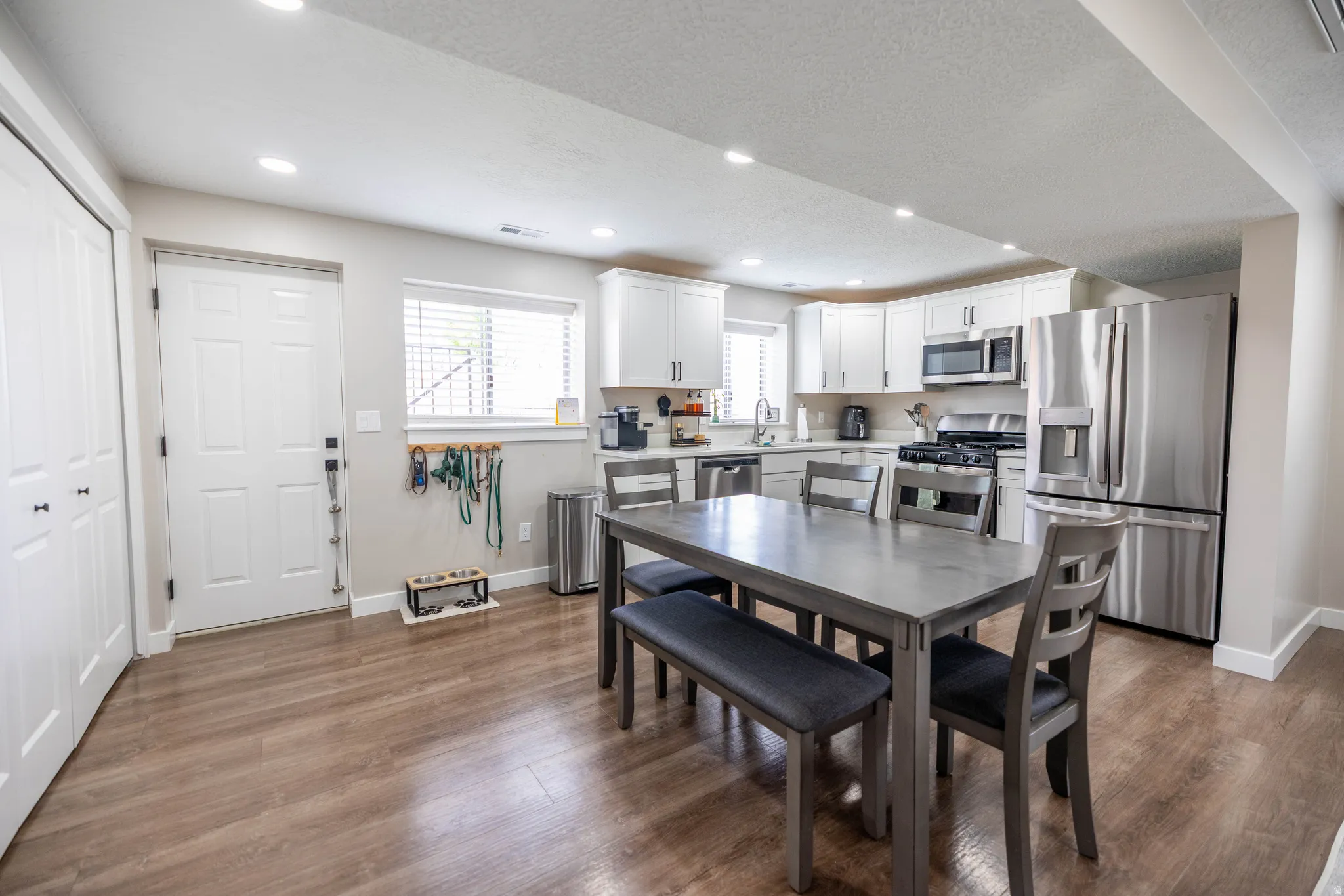 Dining area featuring dark wood-style floors, recessed lighting, and a textured ceiling