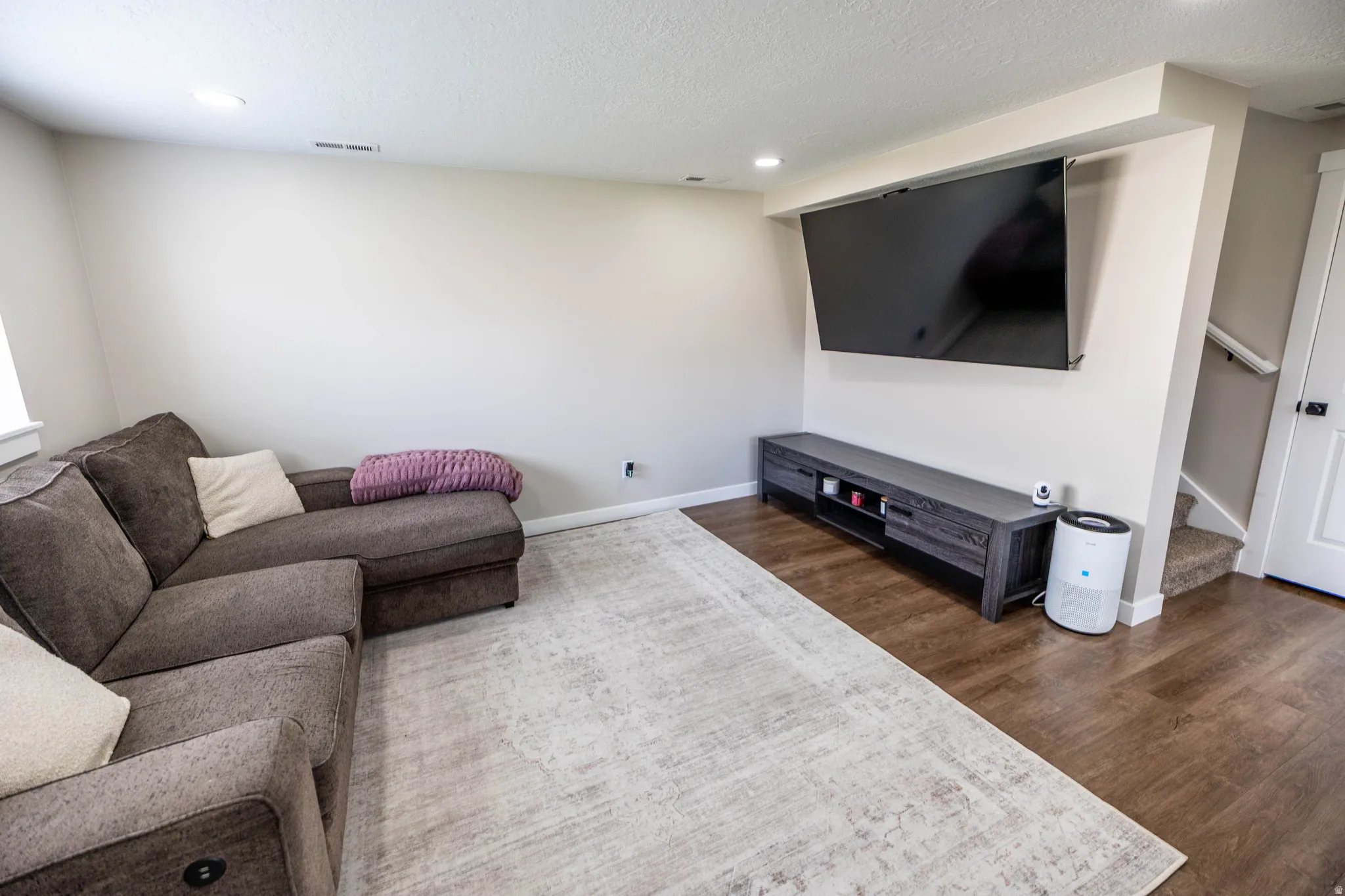 Living room with recessed lighting, dark wood-style floors, and a textured ceiling