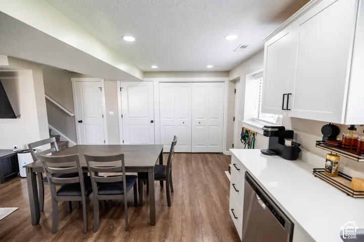 Dining area featuring dark wood-type flooring, a textured ceiling, and recessed lighting