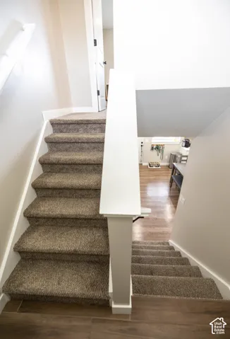 Staircase featuring wood finished floors and baseboards