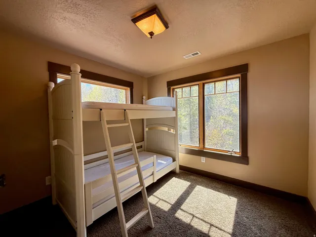 Bedroom with a textured ceiling and carpet