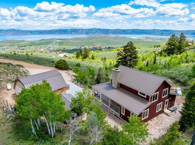 Aerial view of property and surrounding area with a water and mountain view