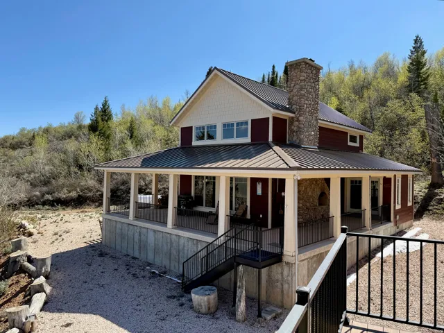 View of property featuring a porch, a standing seam roof, and a chimney