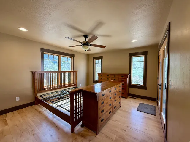 Primary Bedroom featuring light wood-style flooring, a textured ceiling, ceiling fan, and recessed lighting