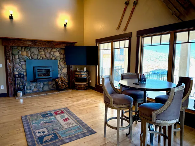 Family room/Dining area featuring light wood-type flooring, a fireplace, and vaulted ceiling