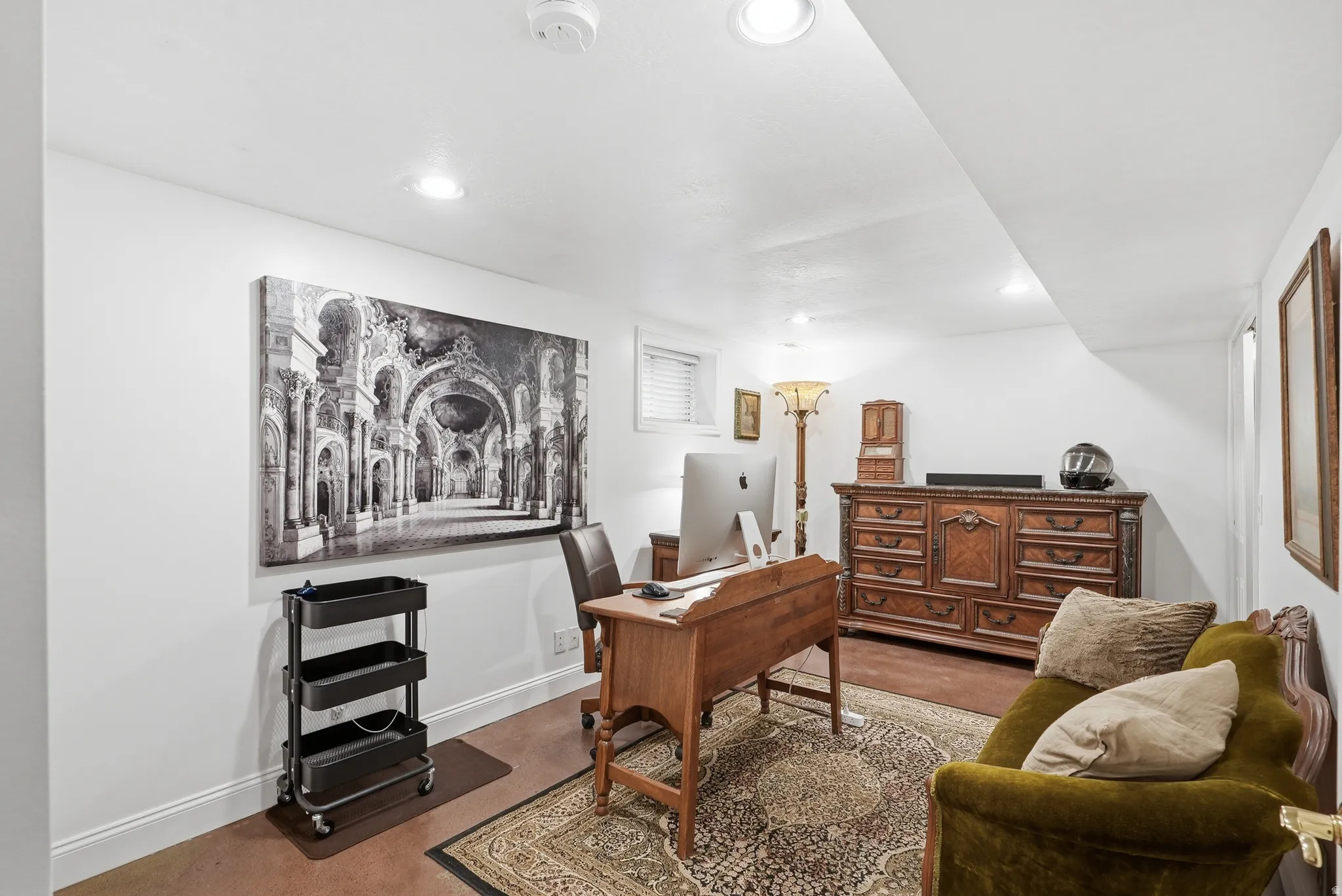 Recessed lighting illuminates this versatile space, featuring wood-finish flooring and white baseboards