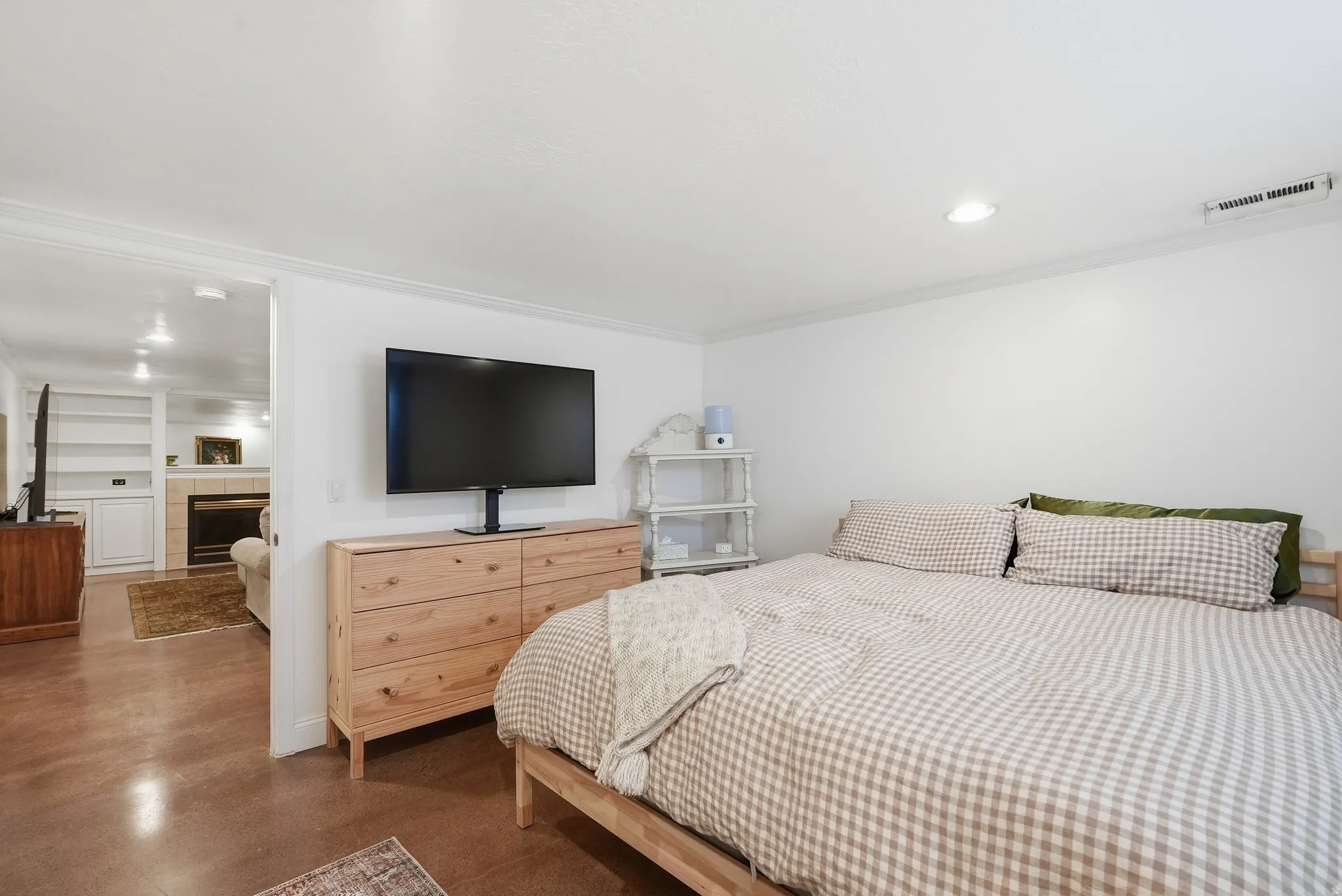 Recessed ceiling lighting illuminates a room featuring white walls and a wide entryway