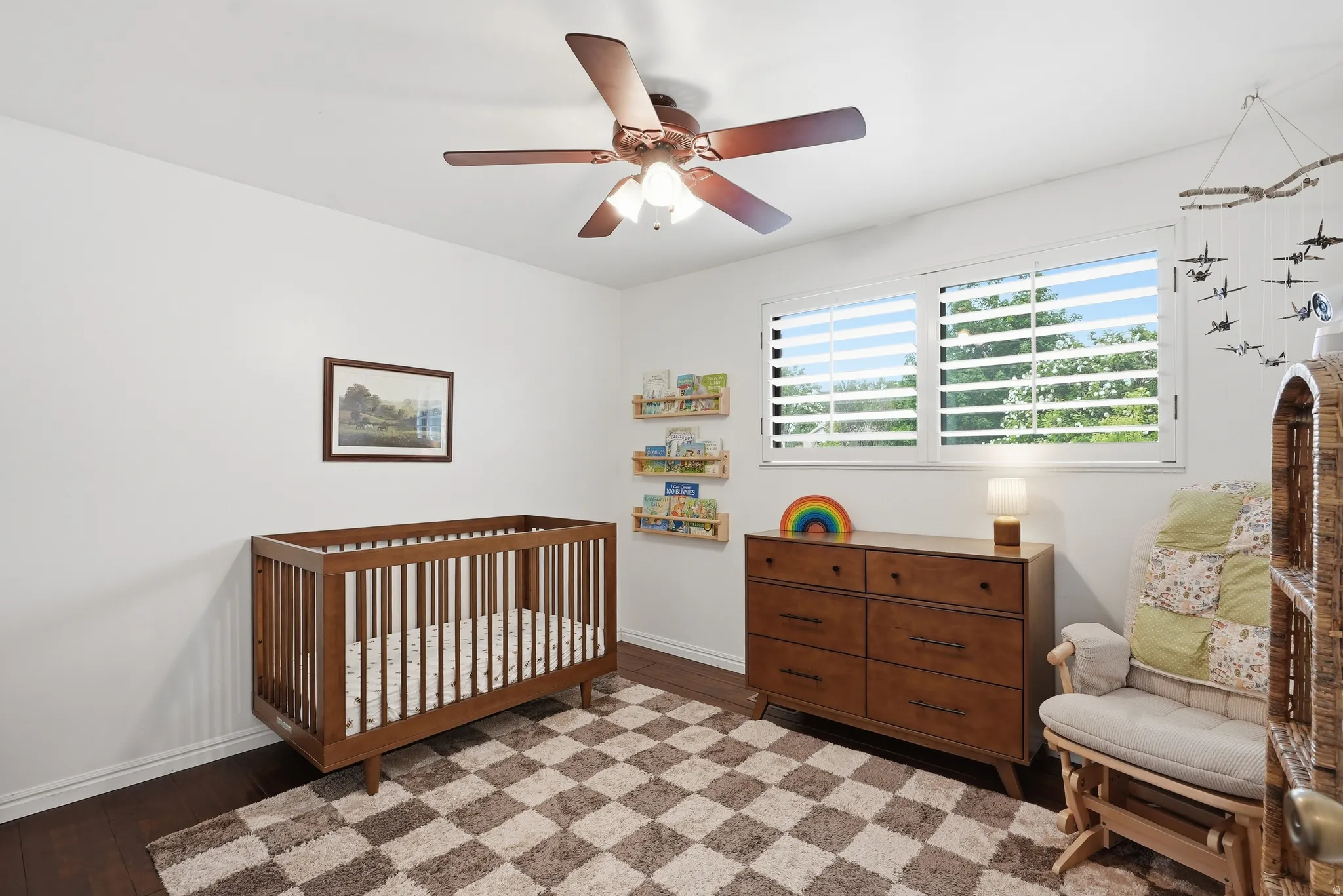 Bedroom featuring wood-finish flooring, a ceiling fan with integrated lighting, and white walls