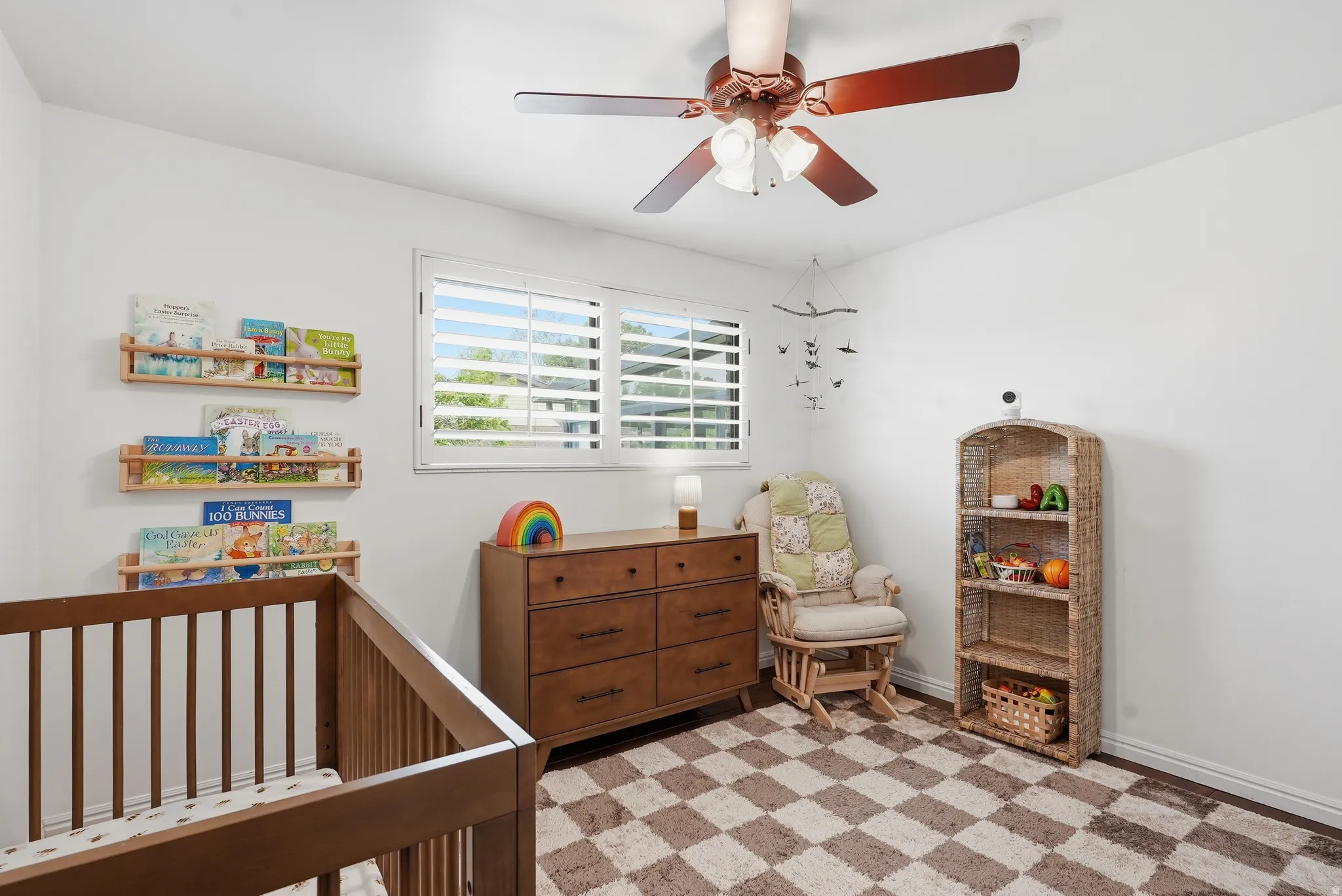 Bright room featuring white walls, a ceiling fan with integrated lighting, and plantation shutters