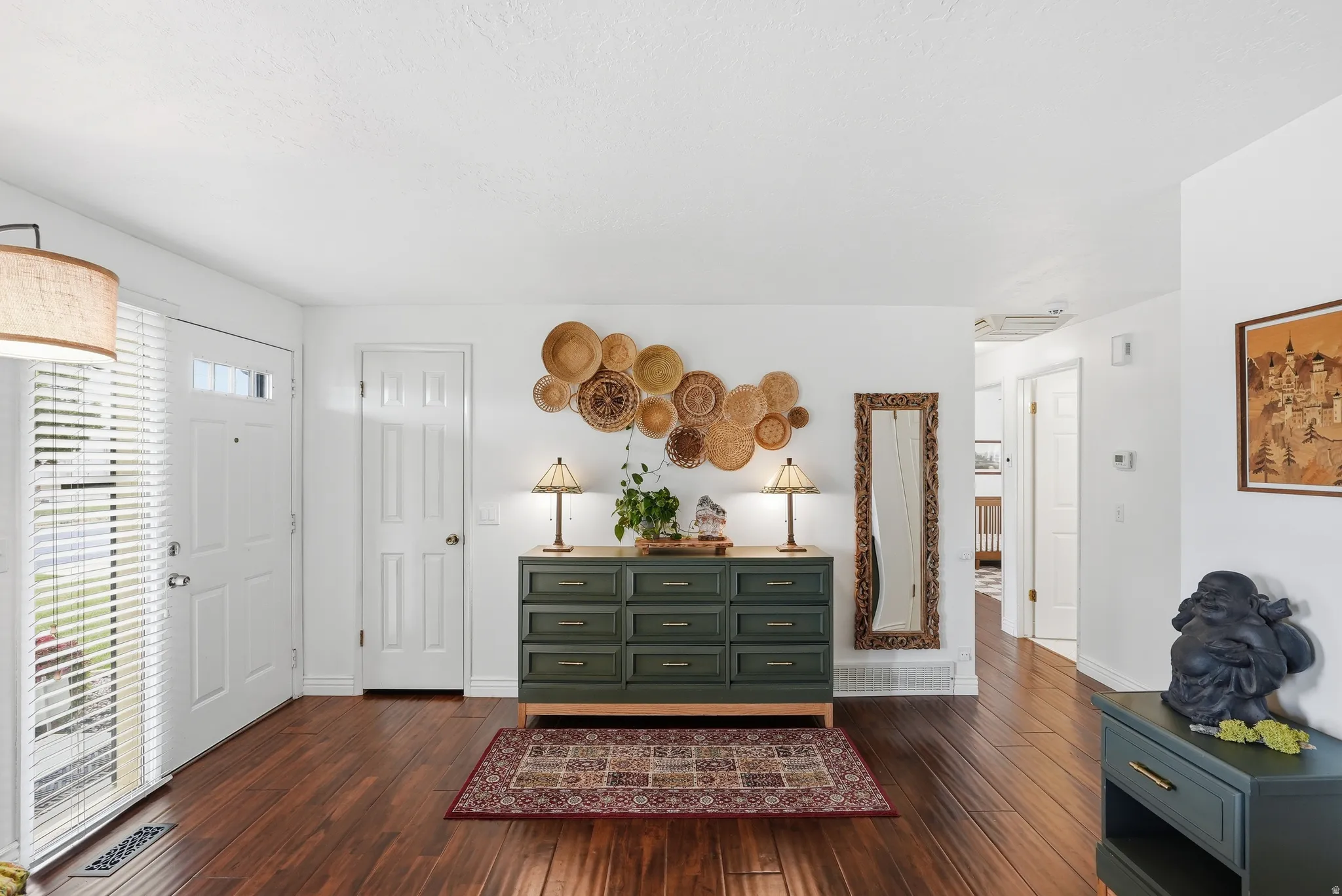 Entryway featuring wood-finish flooring, white paneled doors, and a decorative light fixture