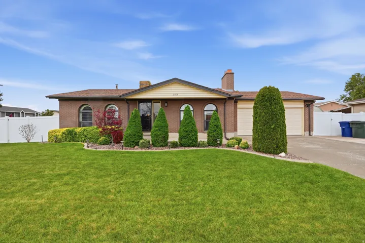 Brick ranch-style residence featuring a prominent front lawn