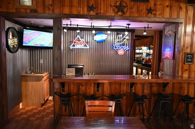 Custom bar area featuring wood paneling and a corrugated metal accent wall