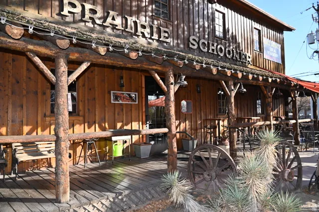 Rustic wood-sided building featuring a porch with log pillars and wood plank flooring