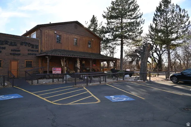 Two-story wood-sided building featuring a covered porch, multiple windows, and a prominent "GENERAL STORE" sign