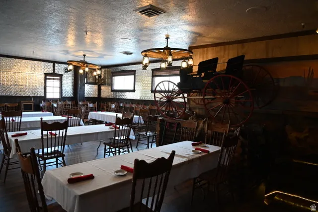 Spacious dining area featuring wood-finish flooring, pressed metal ceiling, and wall paneling