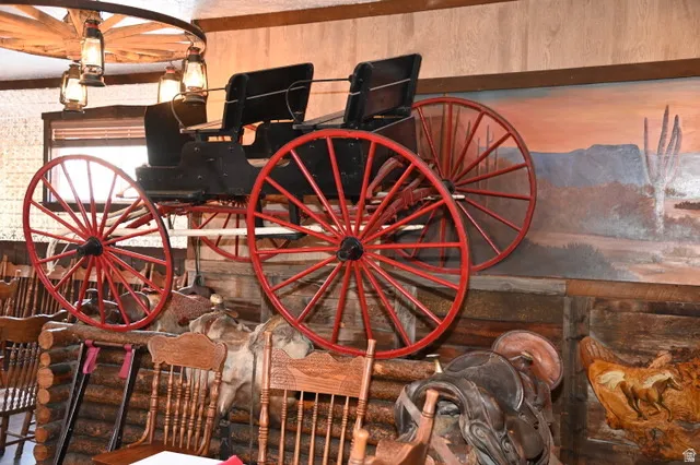 Wood-paneled interior featuring a wagon wheel chandelier with lantern-style lighting