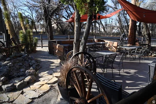 Outdoor patio space featuring multiple seating areas, flagstone pathway, and shade canopies