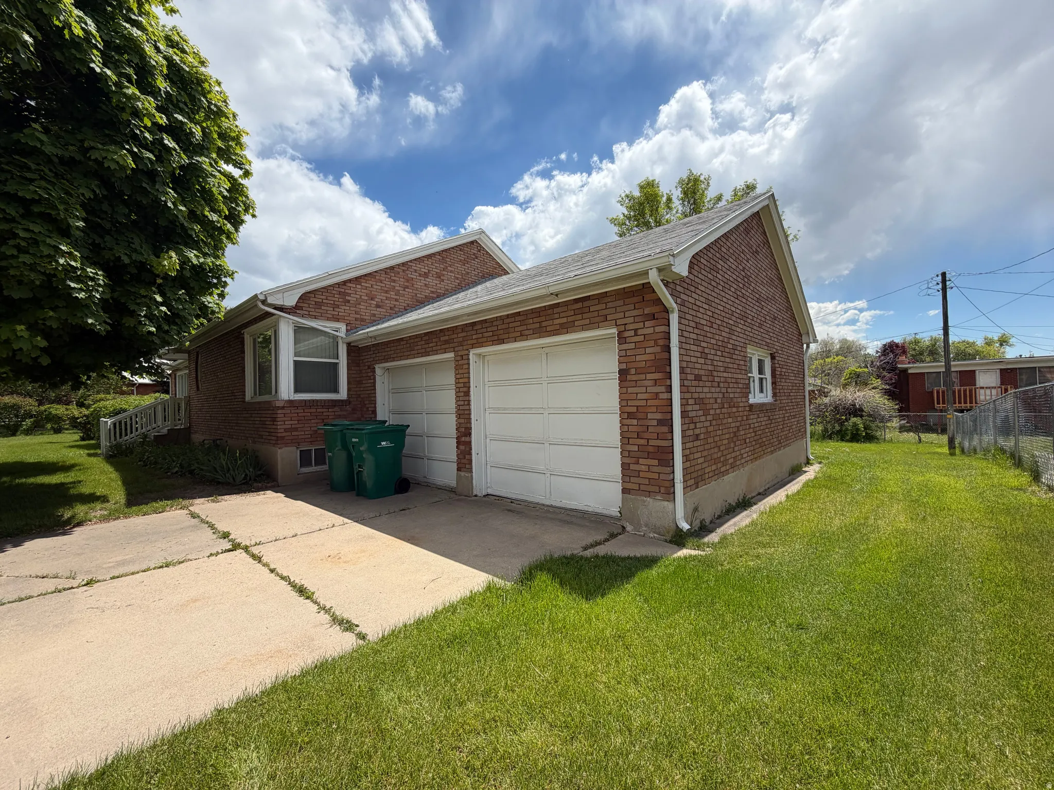 Brick exterior with a double garage and concrete driveway