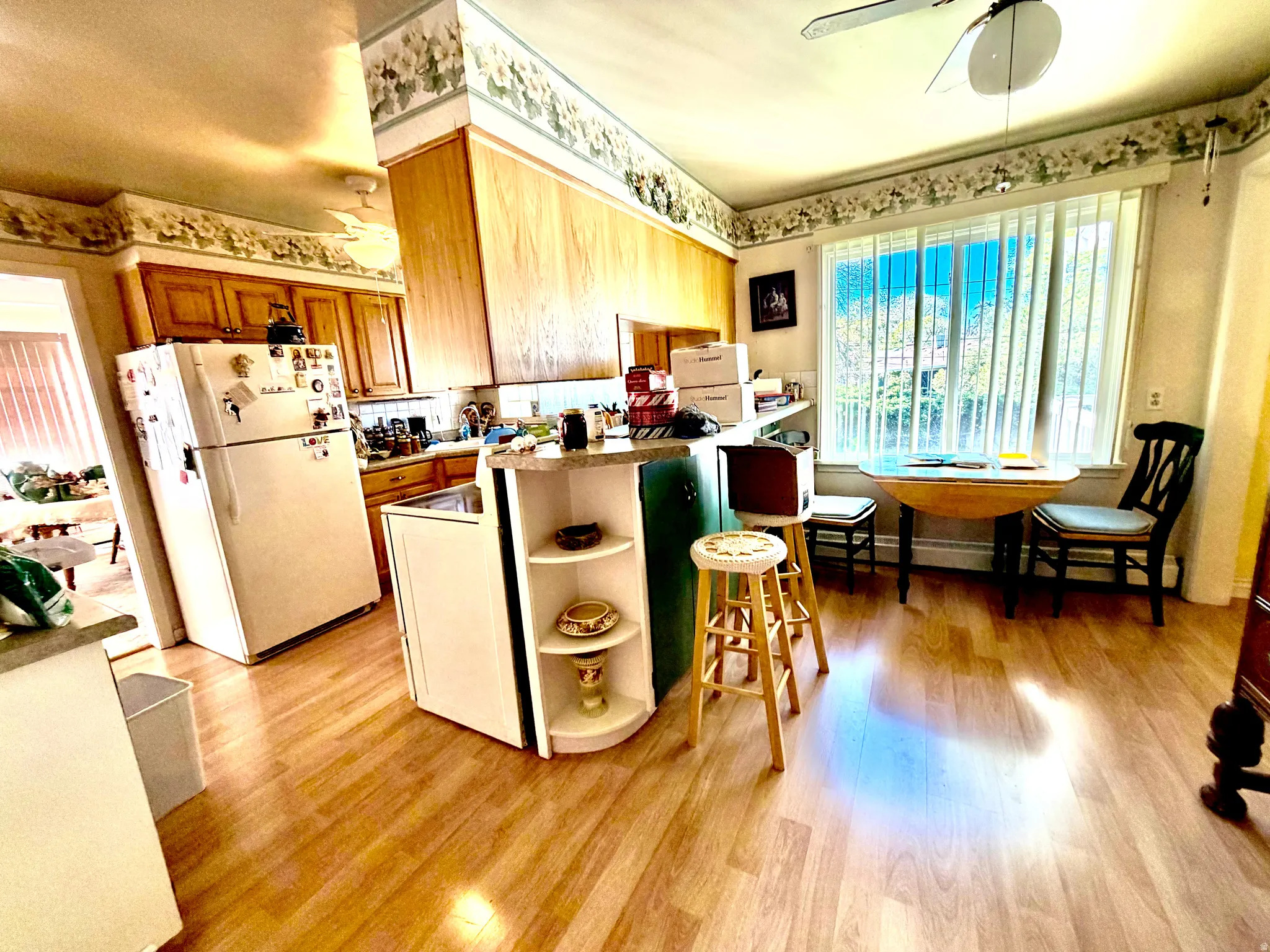 Kitchen with wood-finish flooring, wood cabinetry, and a ceiling fan