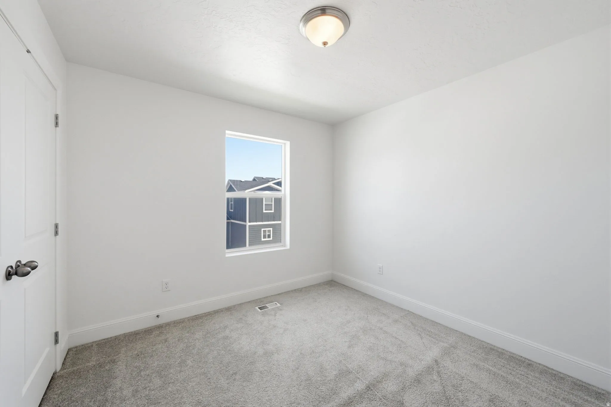 Empty room featuring baseboards and light colored carpet