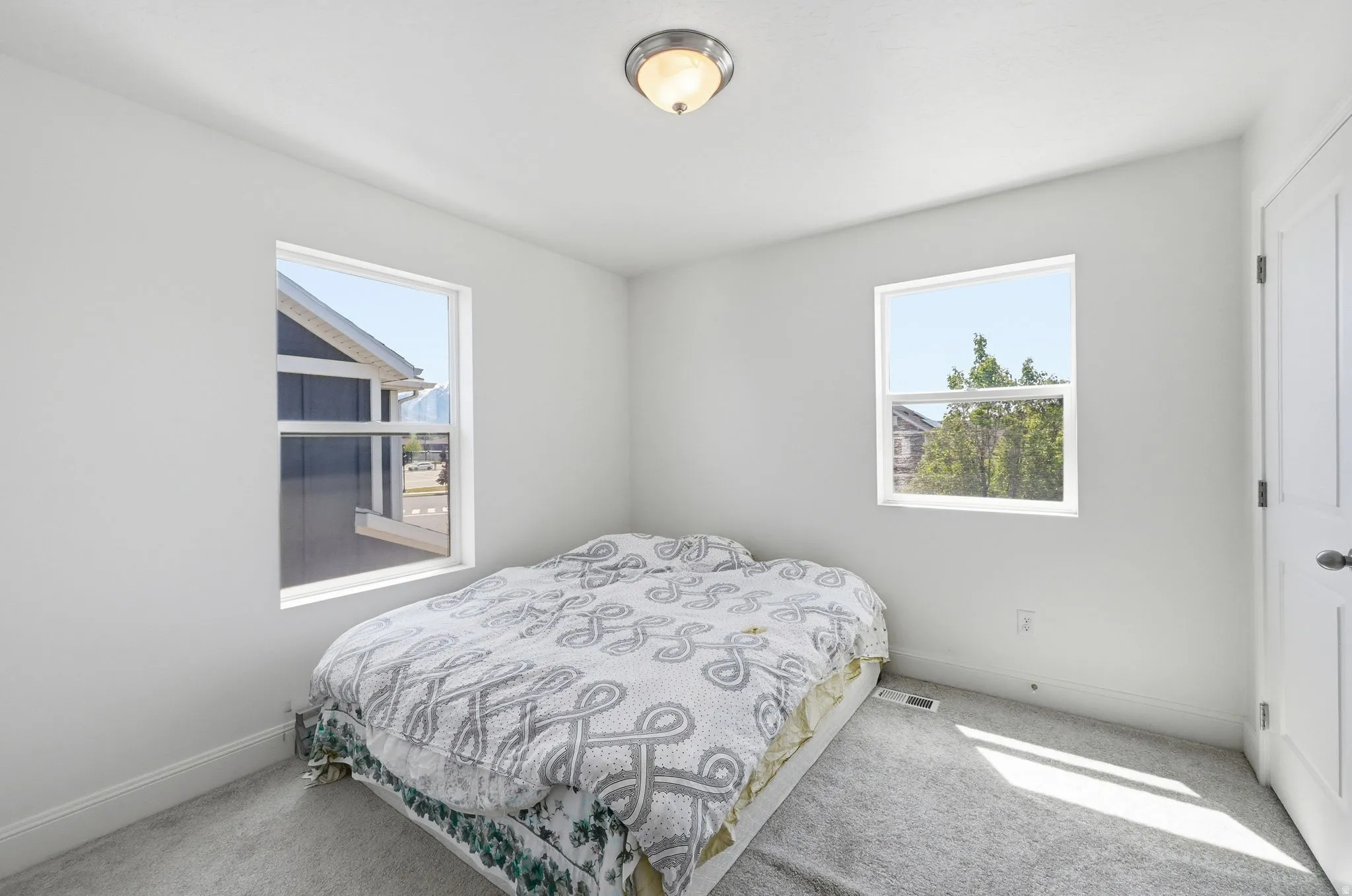 Bedroom with multiple windows and carpet