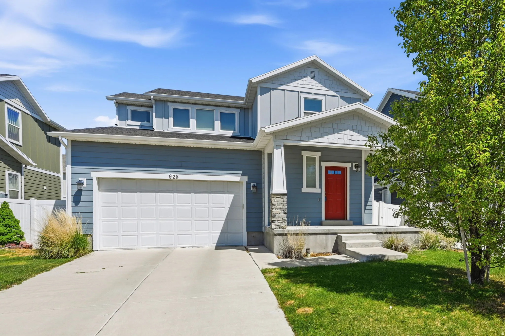 Craftsman inspired home featuring a garage and driveway