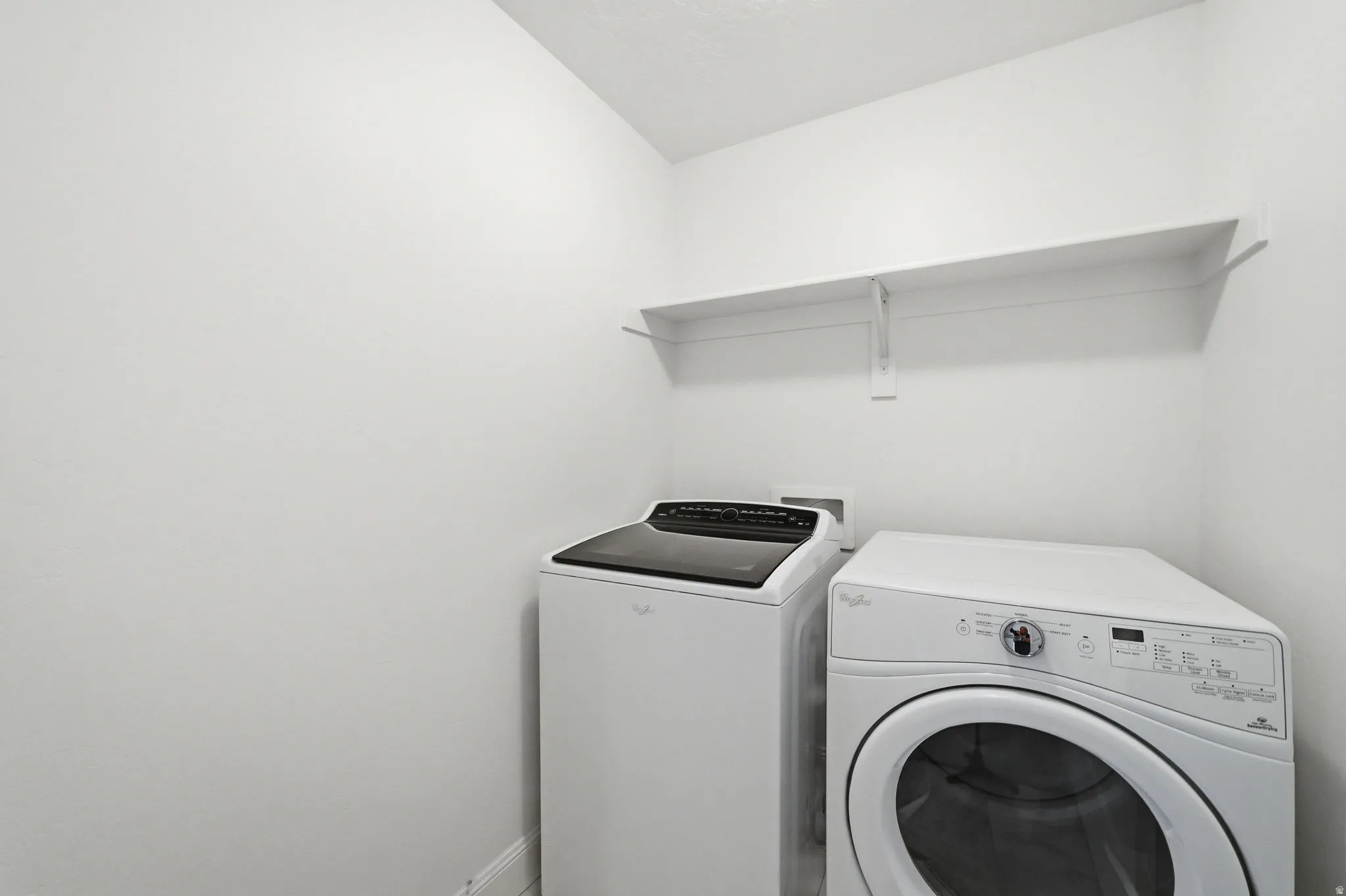 Laundry area with independent washer and dryer and baseboards