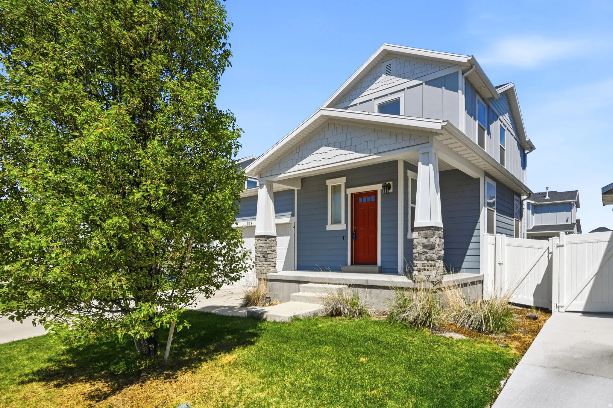Craftsman house with covered porch, a gate, a front lawn, and board and batten siding