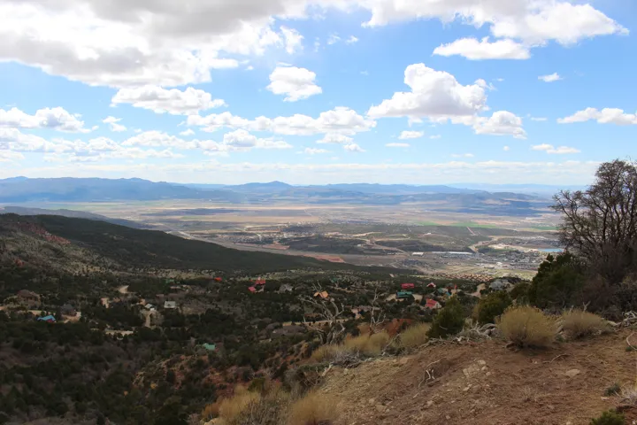 Expansive mountain and valley landscape with distant structures