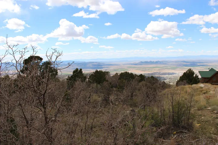Expansive natural landscape with distant mountain ranges and a visible town below