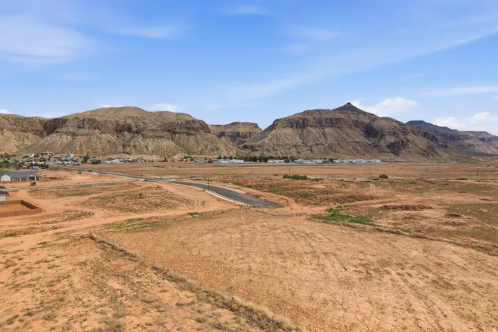 Expansive desert terrain with distant mountain formations under a clear sky