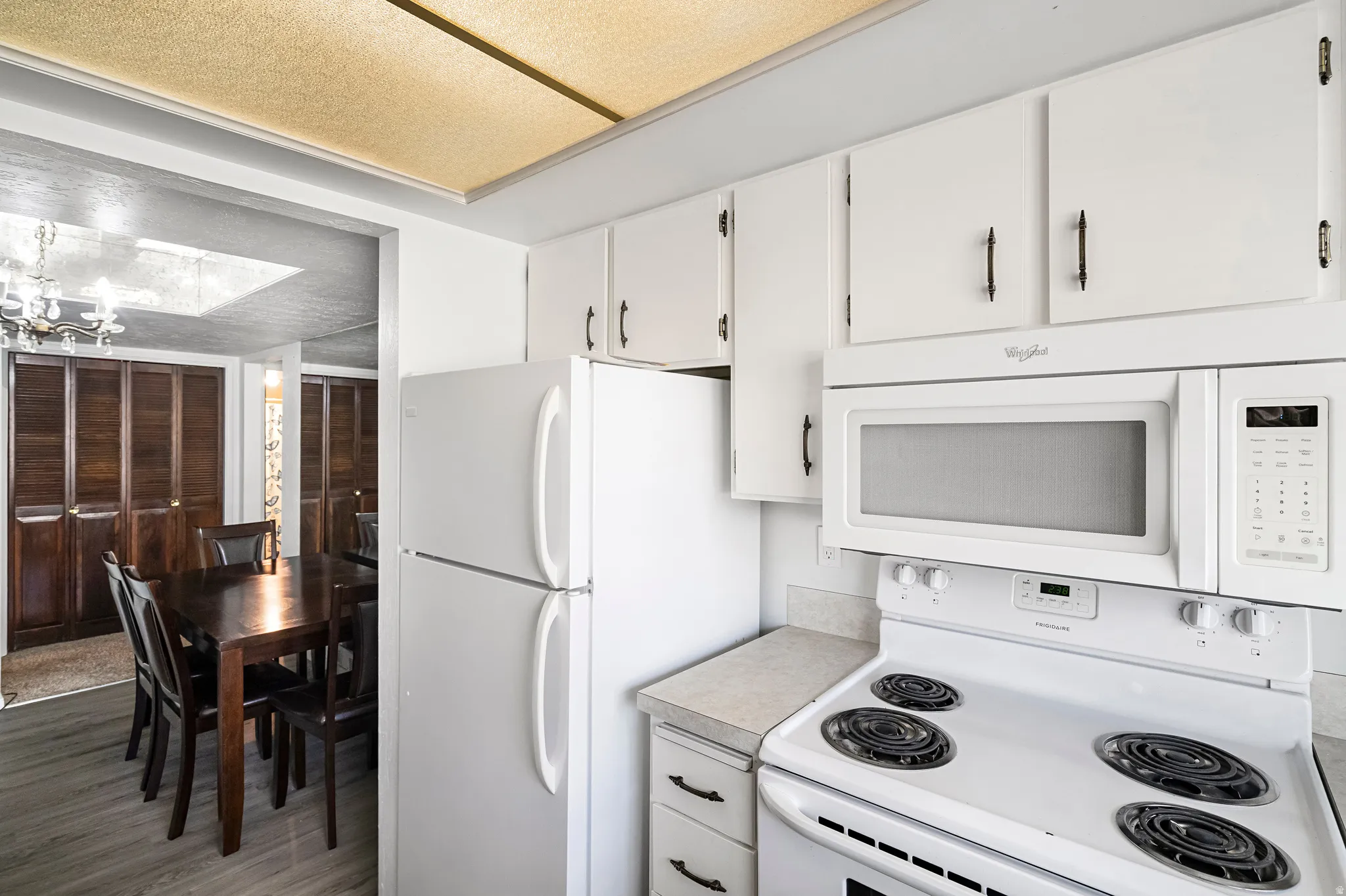 Kitchen featuring white cabinetry, coordinating appliances, and light-toned countertops