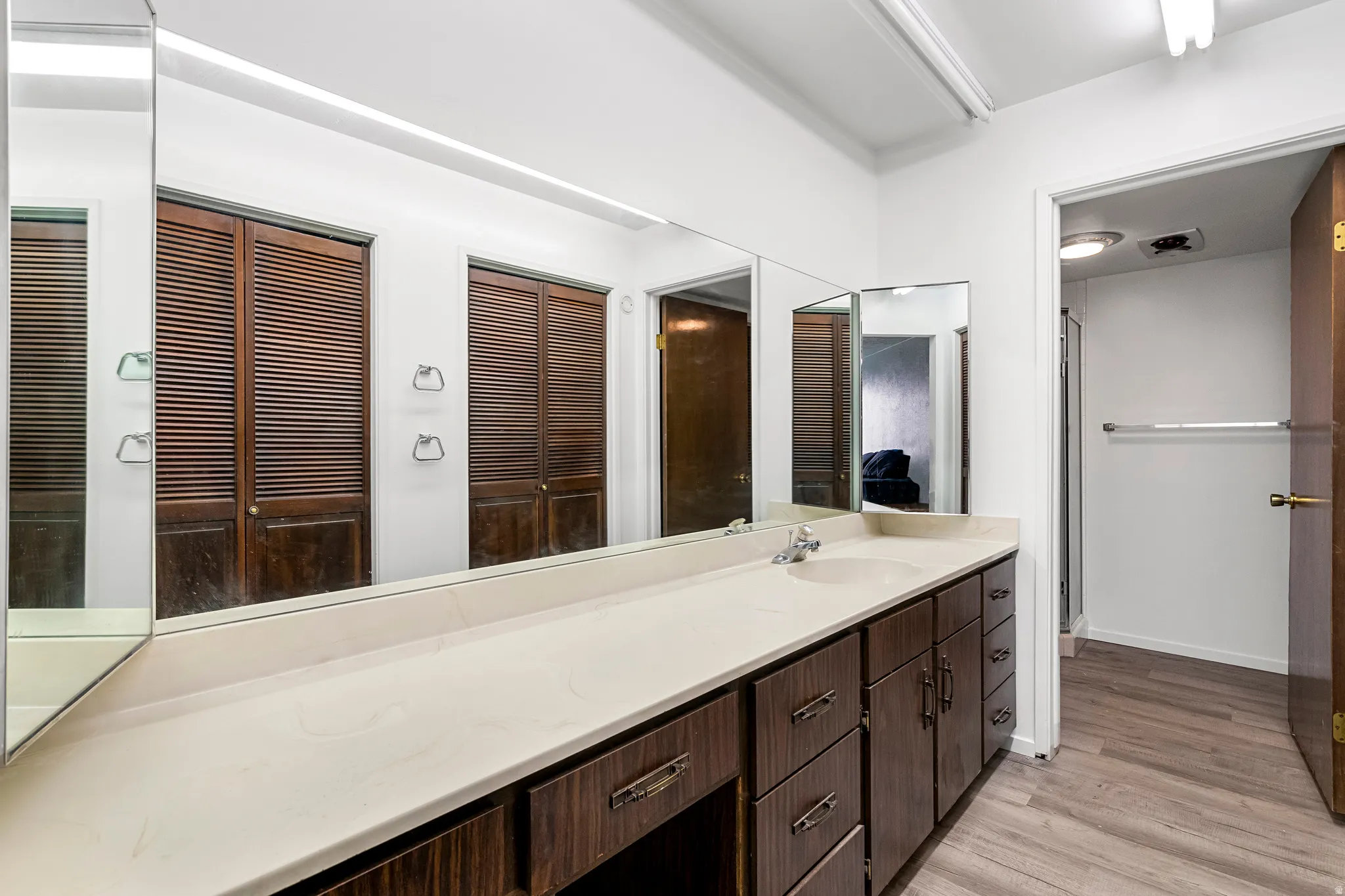 Bathroom vanity with a large countertop, integrated sink, and wood-finish cabinetry