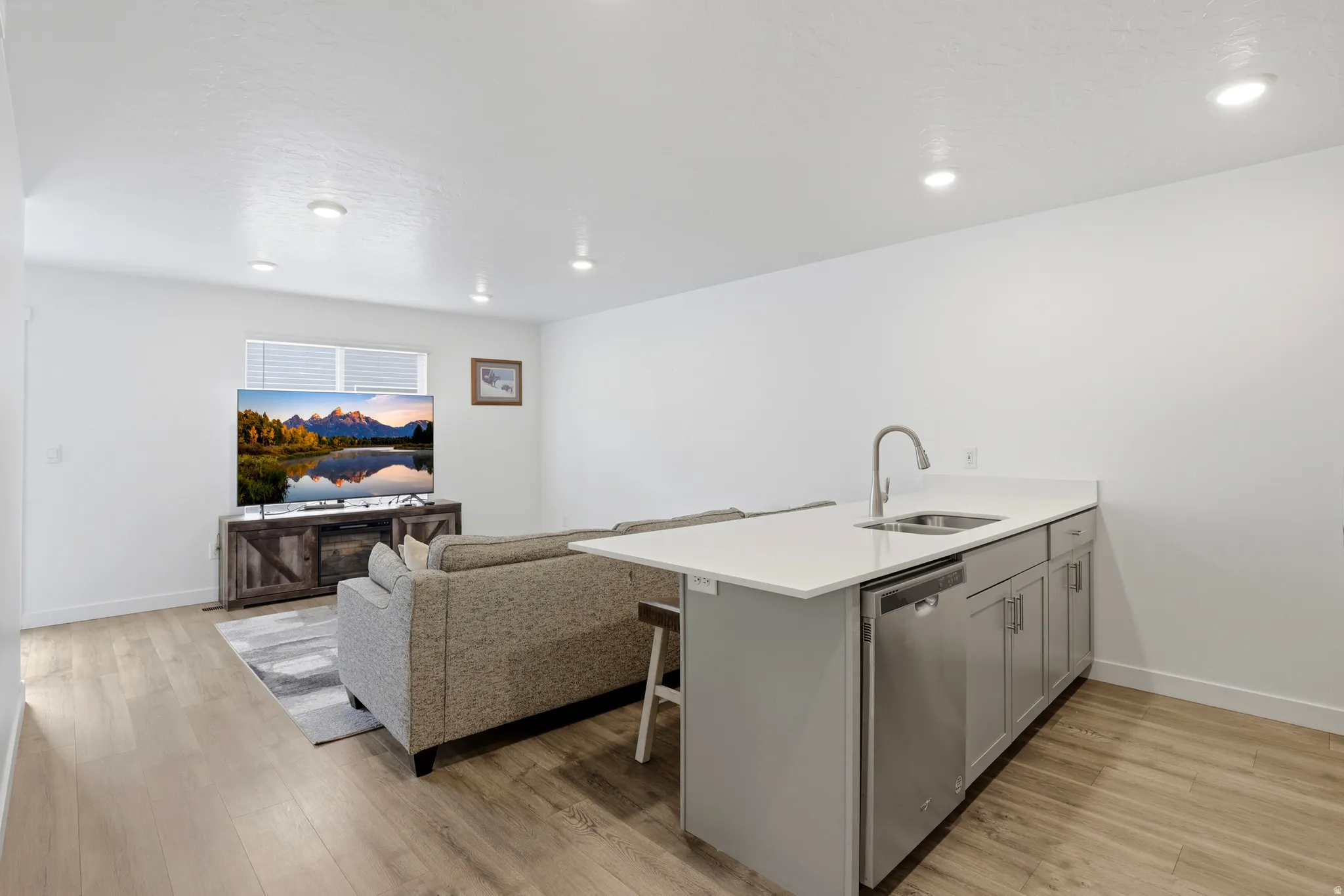 Contemporary kitchenette island with a stainless steel sink, gooseneck faucet, and integrated dishwasher